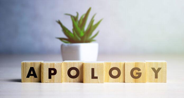 apology - word from wooden blocks with letters, sorry concept, random letters around, white background.